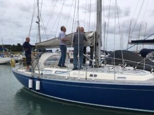 About Us Corporate team members preparing a sailing yacht at the dock, working together on lines and sails during a corporate sailing team-building experience.