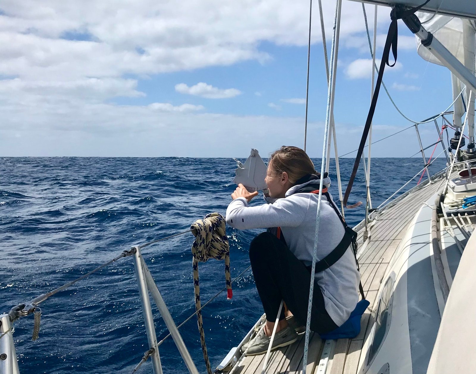 Maud Demazure taking a meridian sight with a sextant during offshore navigation at sea